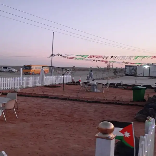 Camp grounds at dusk with seating and the Jordanian flag