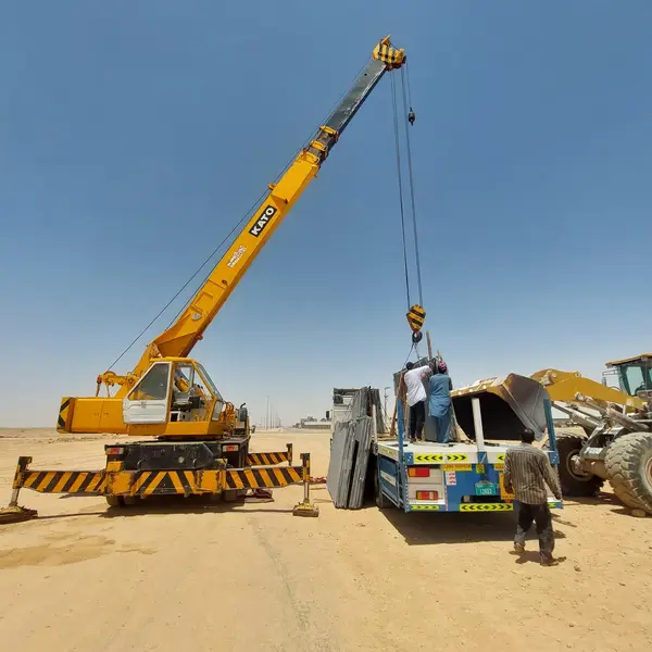 Crane loading site equipment onto a flatbed in the desert