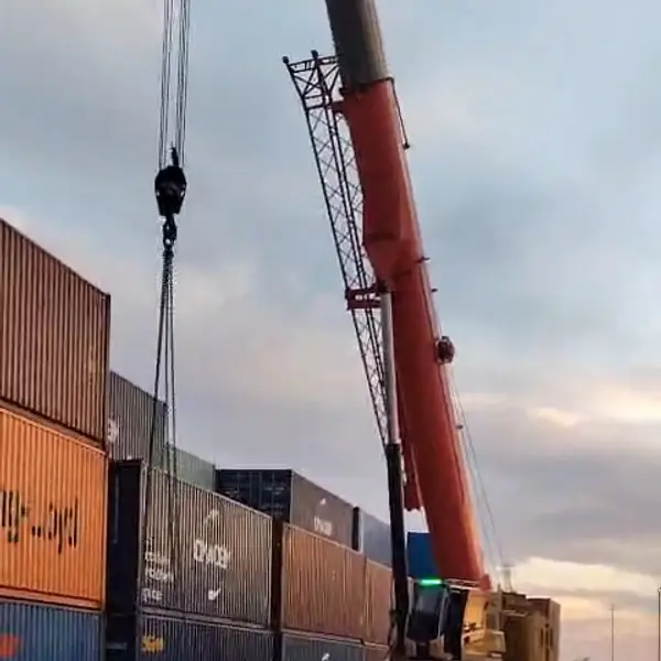 Mobile crane lifting a container from a stack at the Aqaba yard